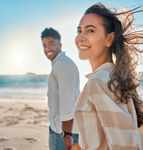 Happy couple strolling on the beach