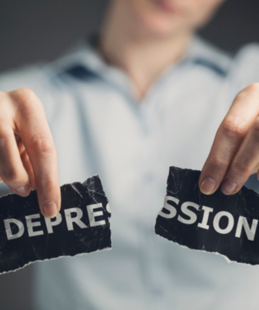 Woman holding ripped piece of paper that says “depression”