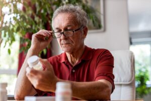 Senior man reading the label on his medication bottle